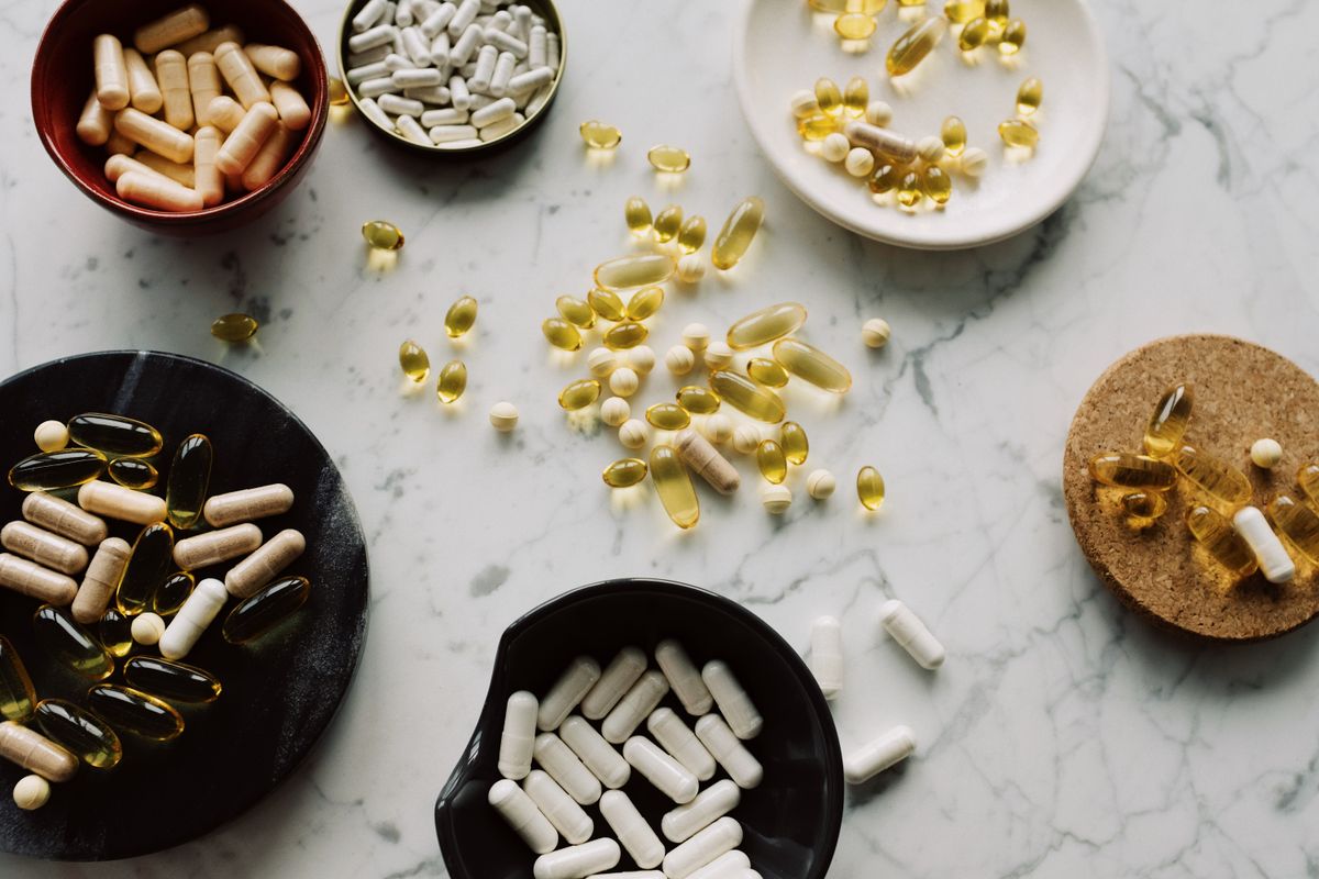 A variety of supplement capsules and softgels arranged for comparison