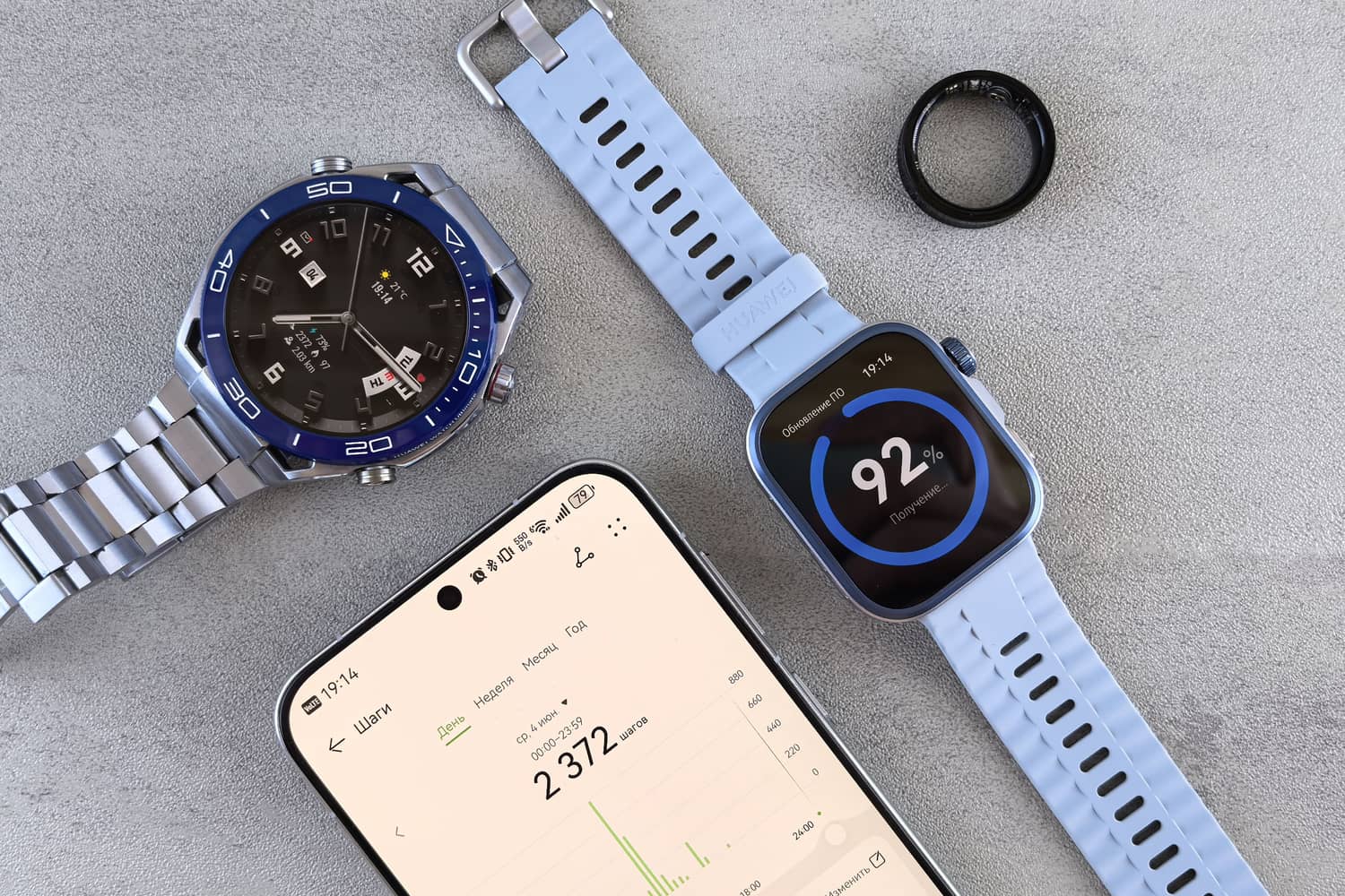 A smartwatch, a health-tracking ring, and a smartphone showing sleep and activity data on a grey surface