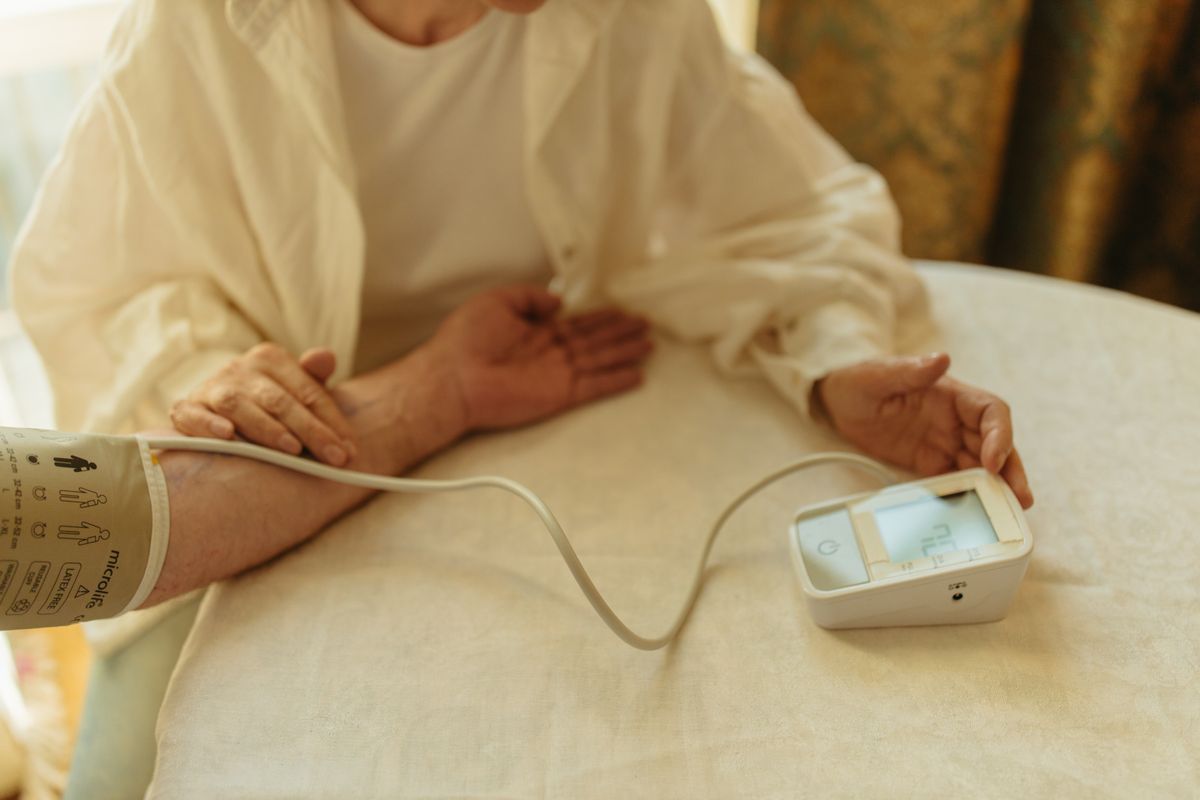 A person checking their blood pressure at home with a digital monitor