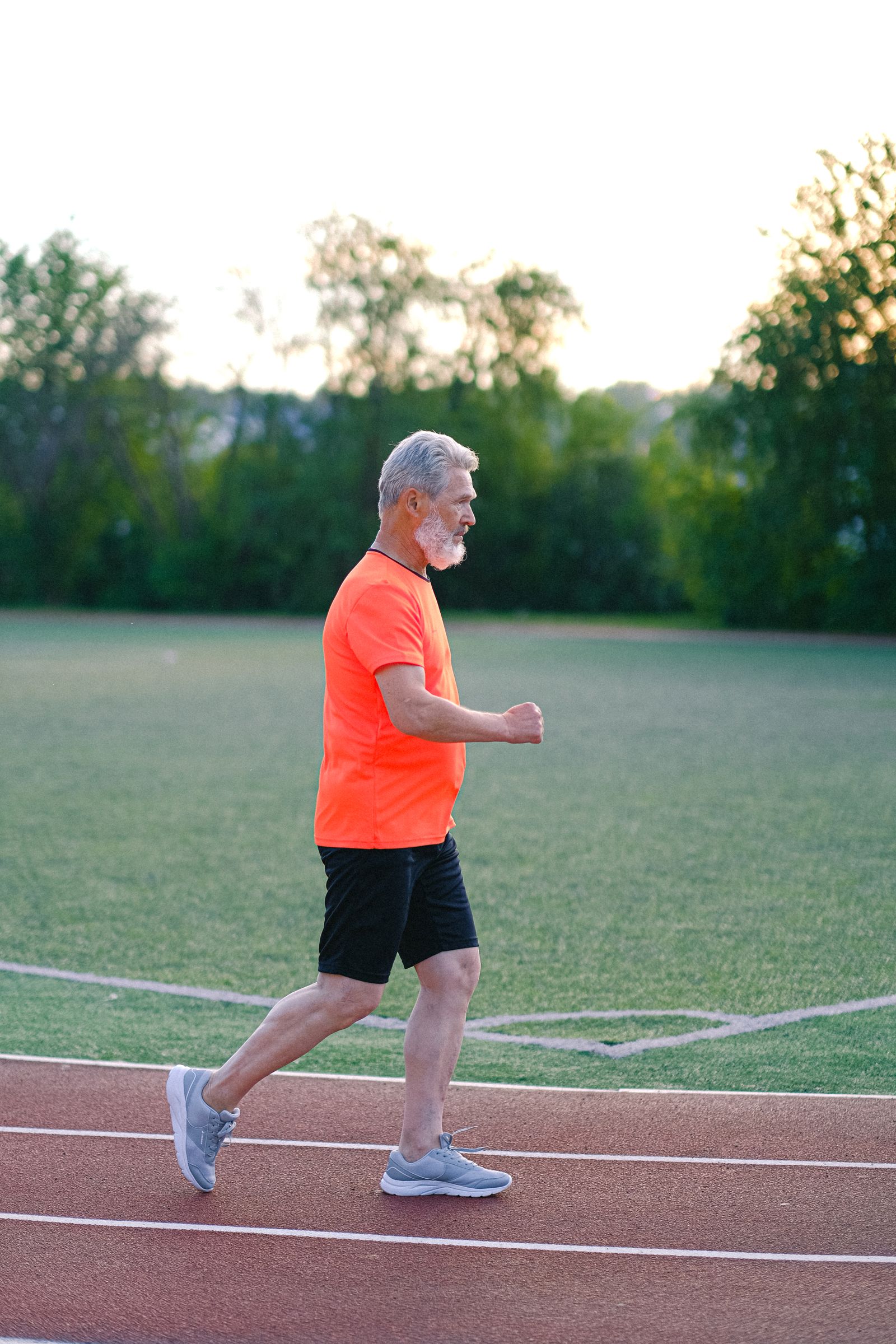 A senior man jogging on an outdoor track as part of a healthy, active lifestyle
