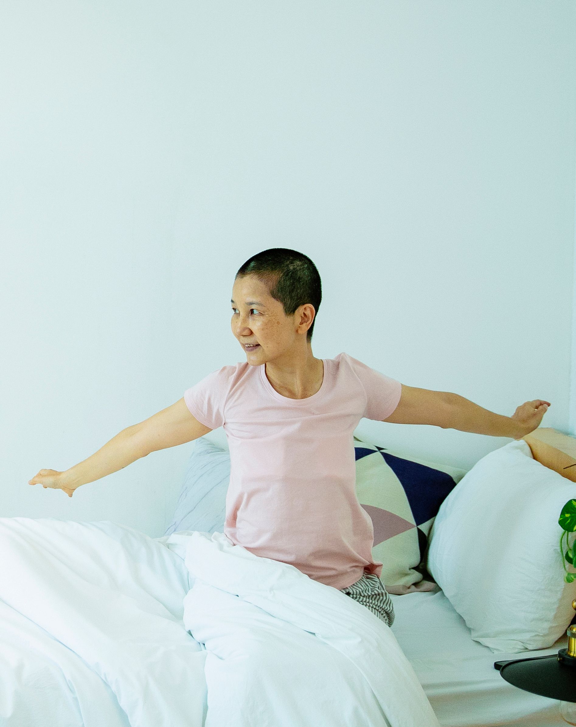 A woman stretching as she wakes up in the morning, representing the natural rise in blood pressure that happens after waking