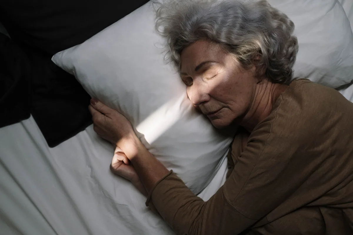 Older woman asleep at night, illustrating nocturnal hypertension, high blood pressure at night that goes unnoticed during sleep
