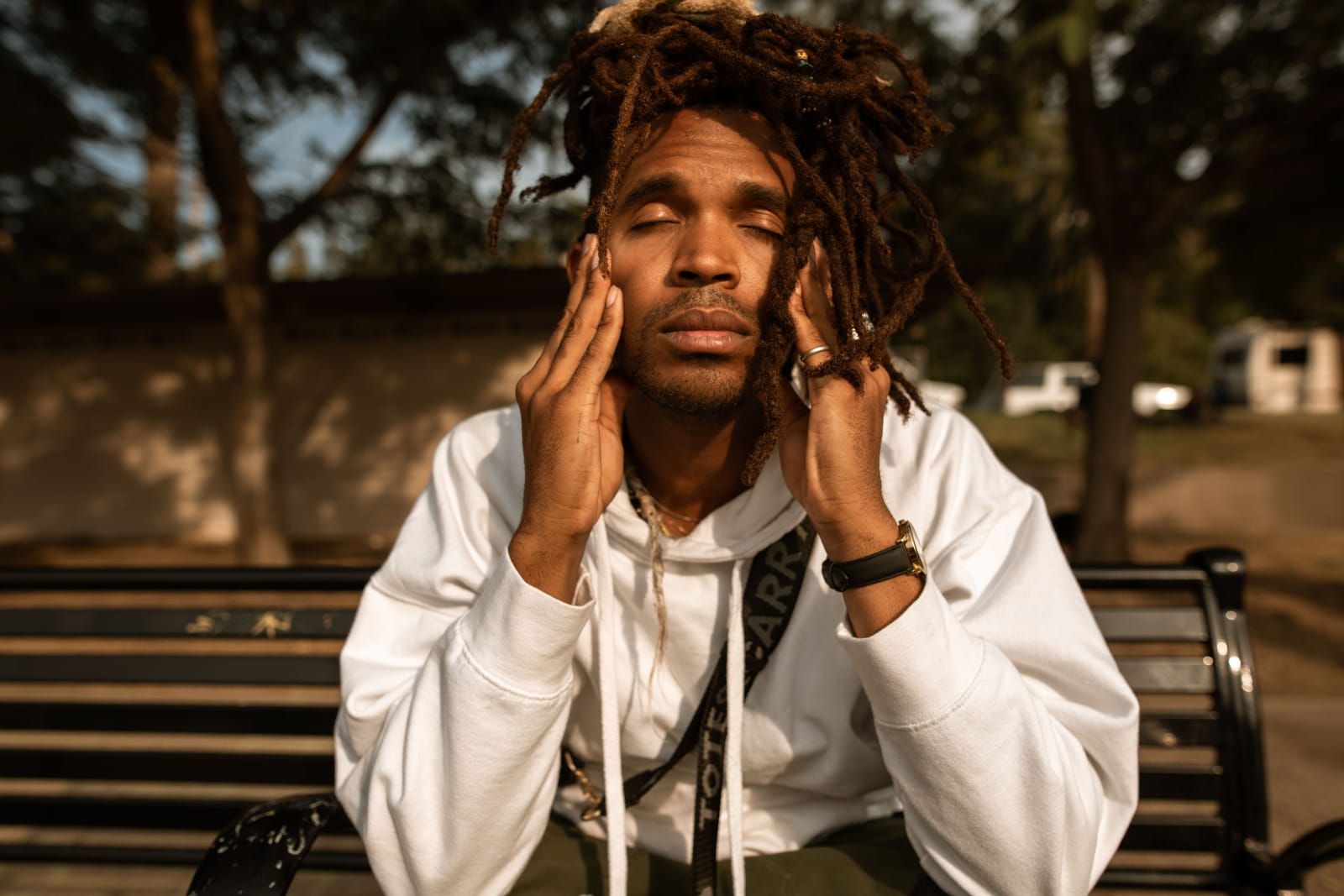 A man sitting outdoors with his hand on his face, representing the temporary physical effects of stress and anxiety