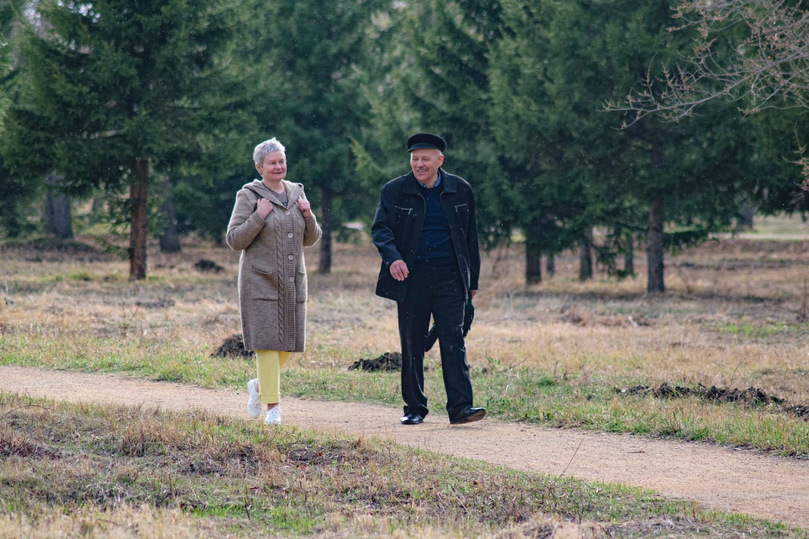 An older couple walking together on an outdoor path, representing consistent exercise for cardiovascular health